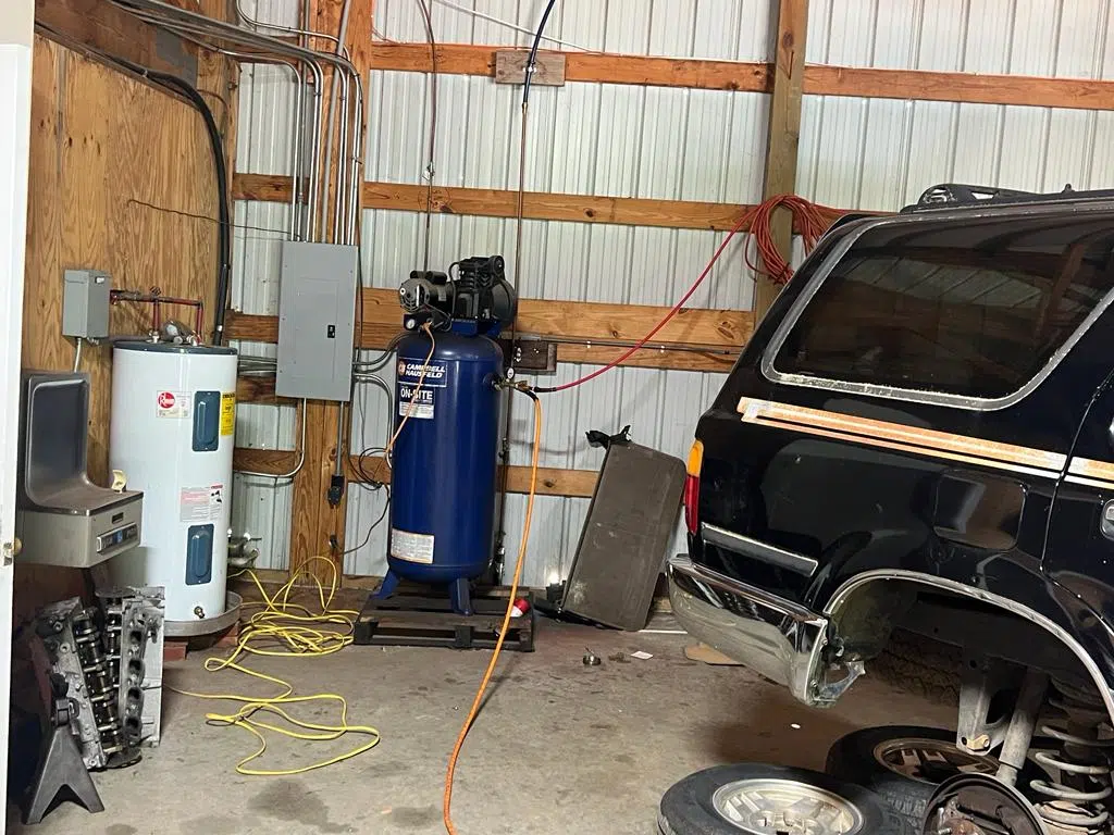 Air compressor and water heater against the shop wall — PIQUET AUTO SERVICE in Greenville
