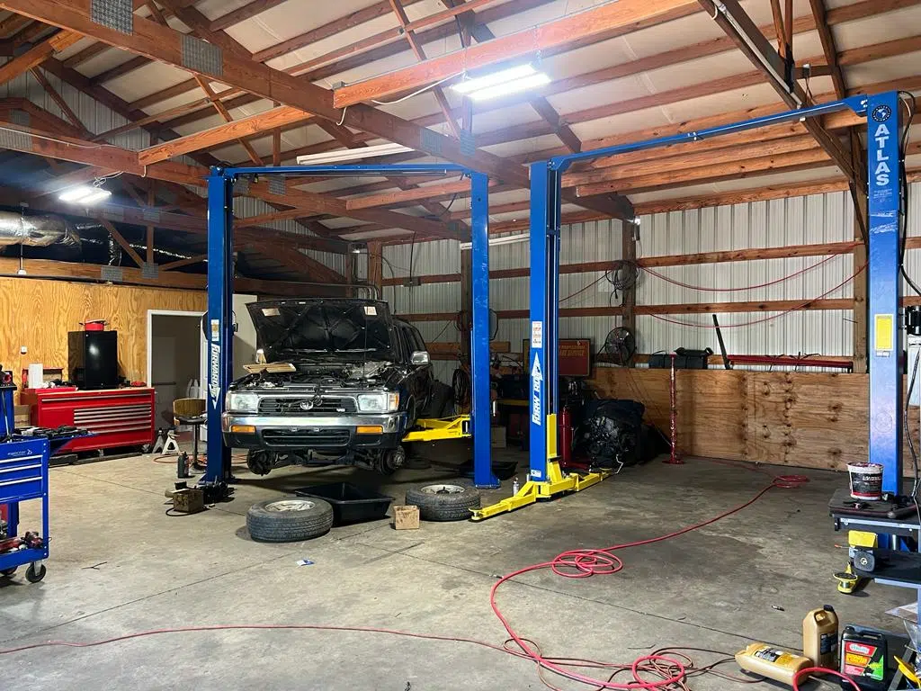 Truck raised on a two-post lift inside the workshop — PIQUET AUTO SERVICE in Greenville